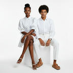 Two people wearing white outfits sitting on a white background
