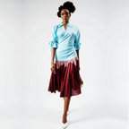 Woman wearing a light blue top and maroon skirt on a white background