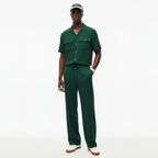 Man wearing a green jumpsuit and cap on a white background