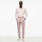 Man wearing a light pink shirt and pants on a white background