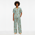Man wearing a tropical patterned pajama set on a white background