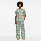 Man wearing a tropical patterned pajama set on a white background
