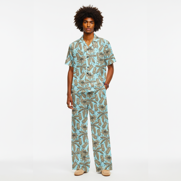 Man wearing a tropical patterned pajama set on a white background