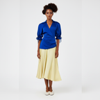 Woman wearing a dress with a  blue top and yellow skirt on a white background