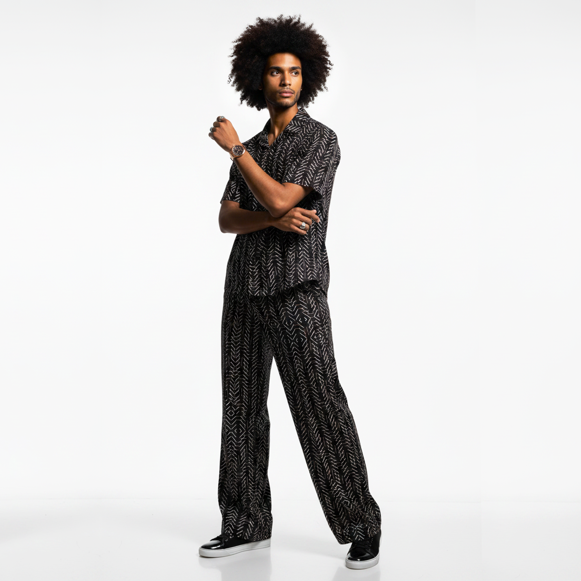 Man wearing a black and white patterned outfit on a white background