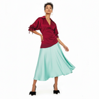 Woman wearing a dress with a red blouse and light blue skirt on a white background