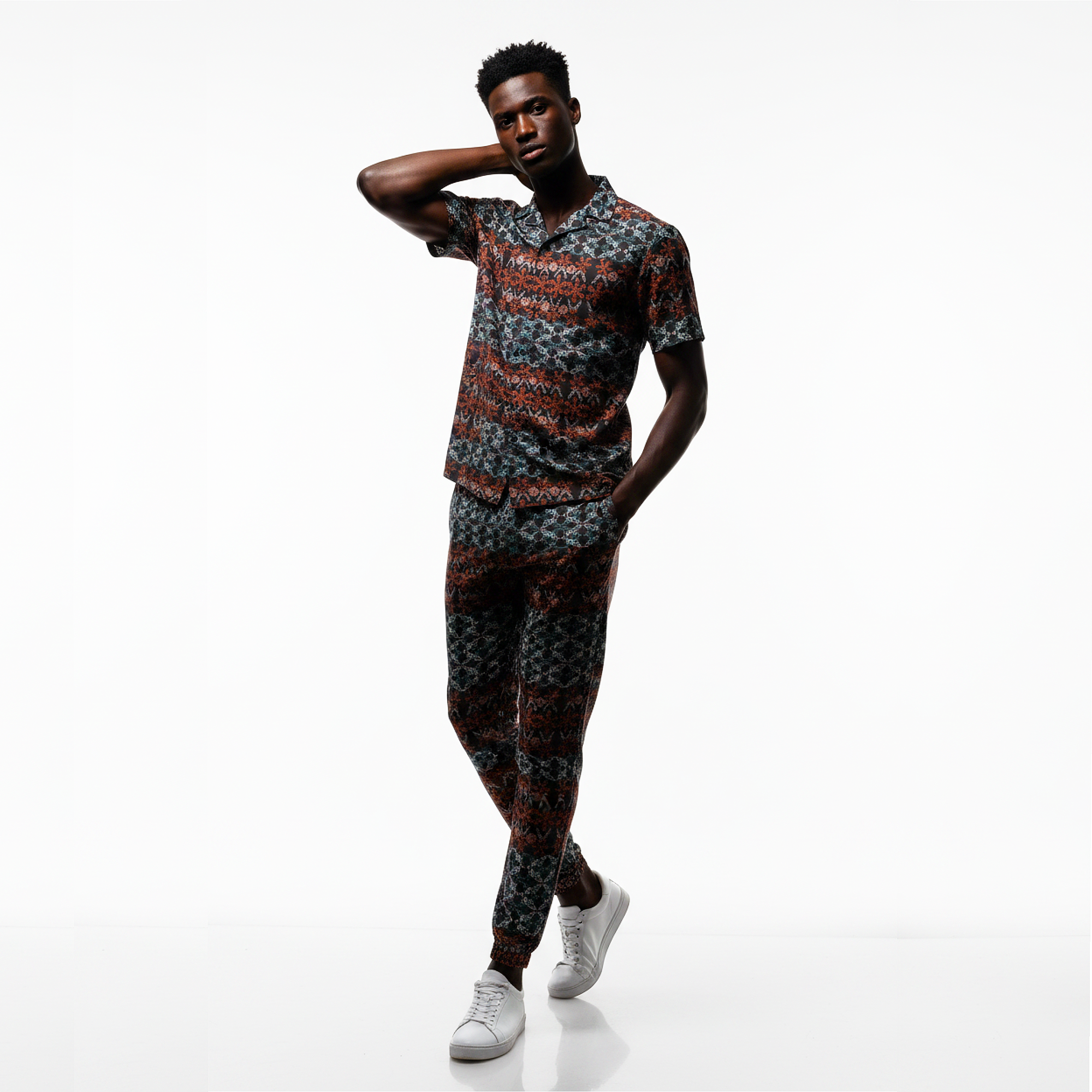 Man wearing a patterned outfit on a white background