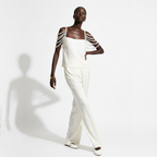 A person wearing a white top with pearl shoulder straps on a white background