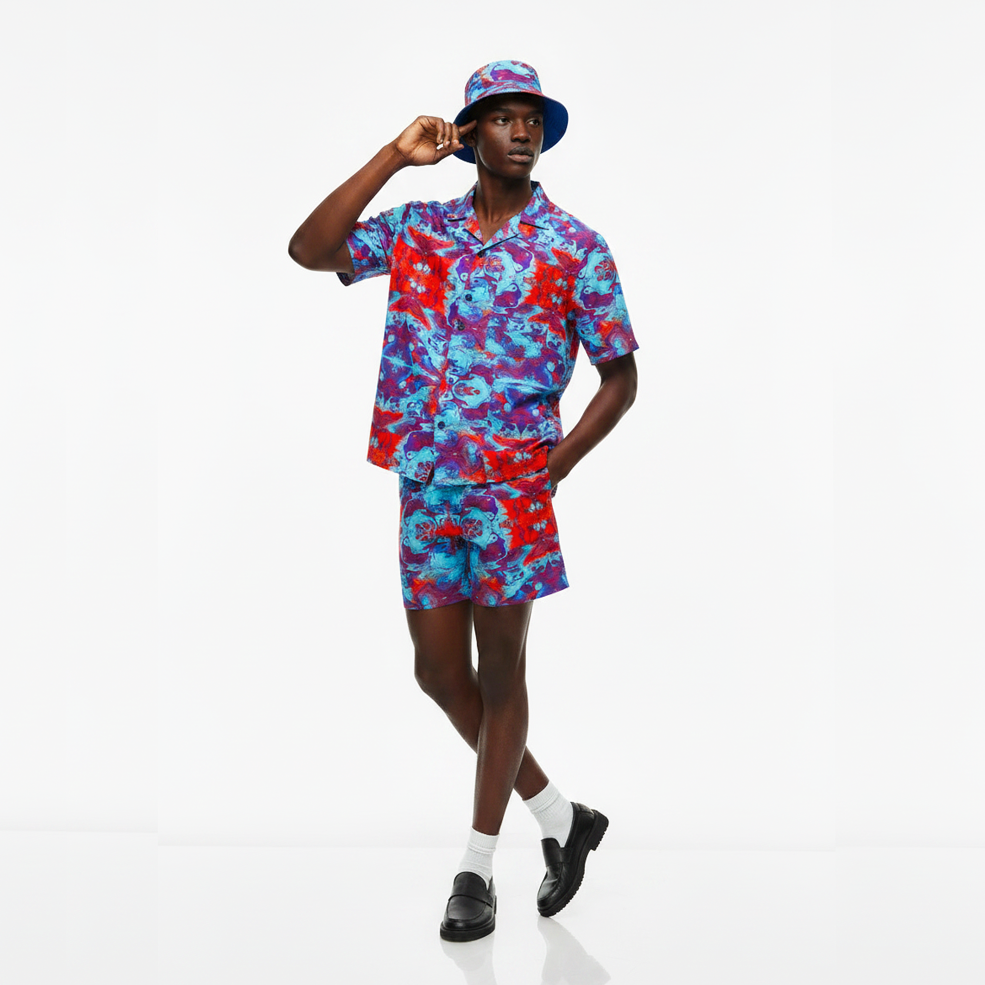 Person wearing a colorful outfit with a matching hat on a white background