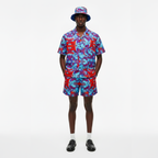 Person wearing a colorful shirt and shorts set with a matching hat on a white background