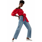 Woman wearing a red off-shoulder top with a blue jeans on a white background