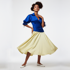 Woman wearing a dress with a blue top and yellow skirt on a white background