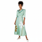 Woman wearing a green dress with floral designs against a white background