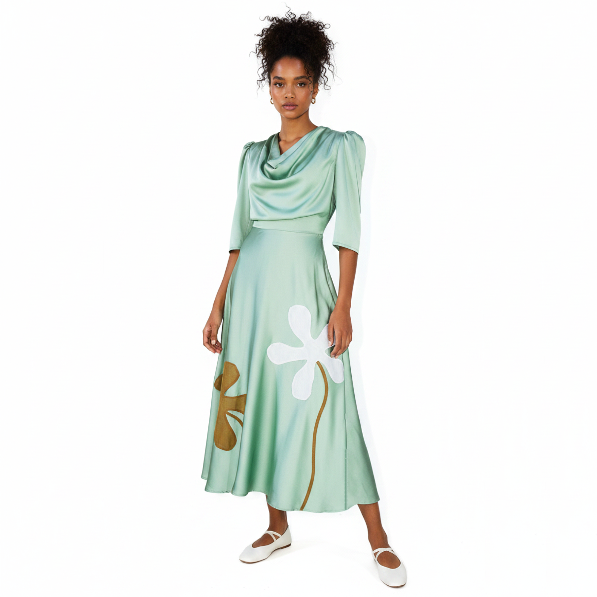 Woman wearing a green dress with floral designs against a white background