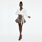 Woman wearing a white blouse and patterned skirt on a white background