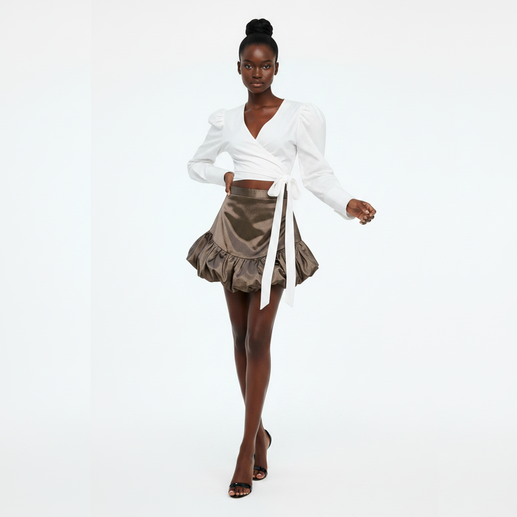 Woman wearing a white blouse and patterned skirt on a white background