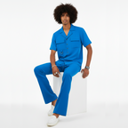 Person wearing a blue outfit sitting on a white stool against a white background