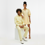 Two people wearing matching yellow outfits on a white background