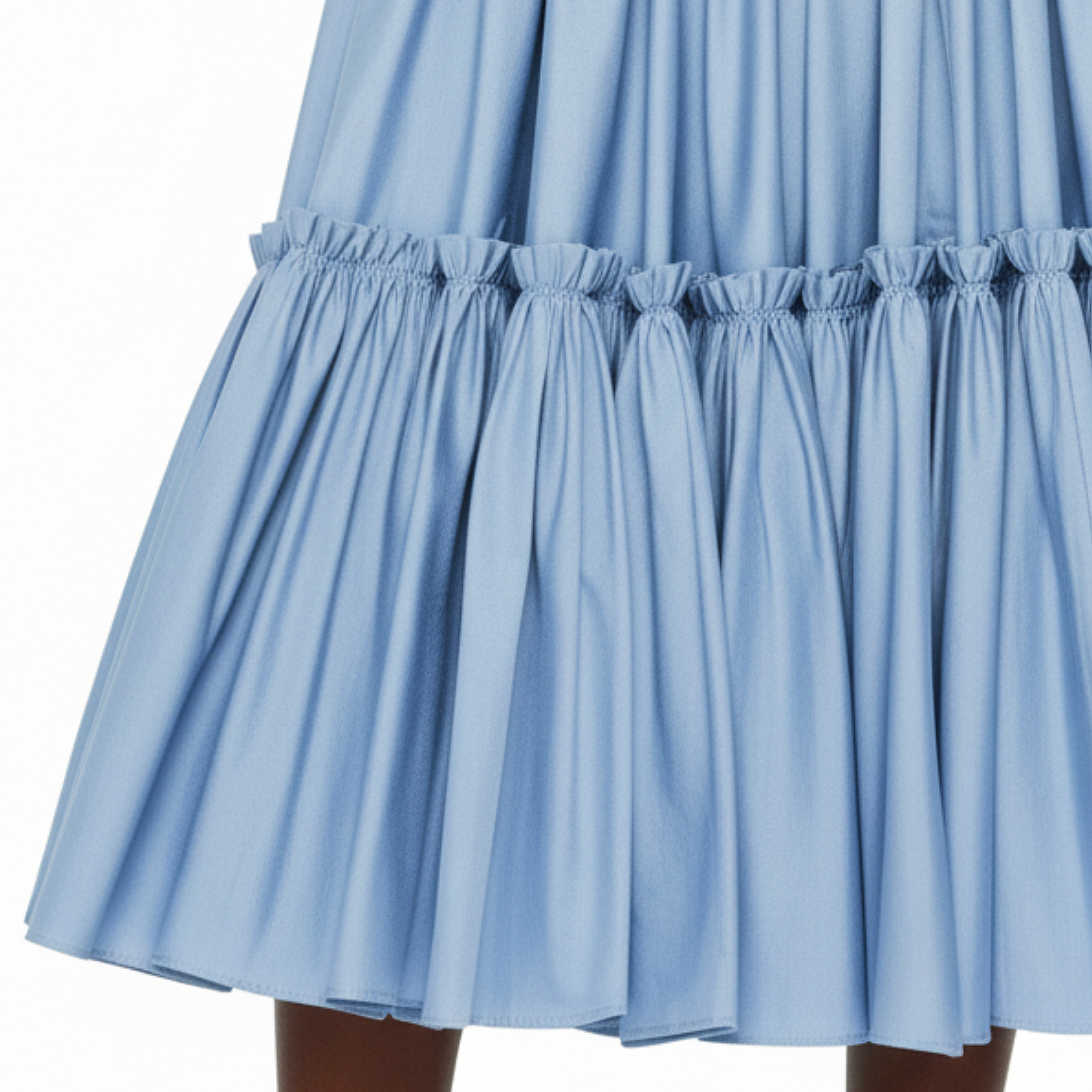 Close-up of a light blue skirt with ruffled hem on a white background