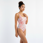 Woman wearing a floral one-piece swimsuit on a white background