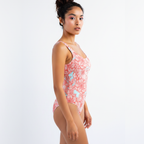 Woman wearing a pink floral swimsuit on a white background