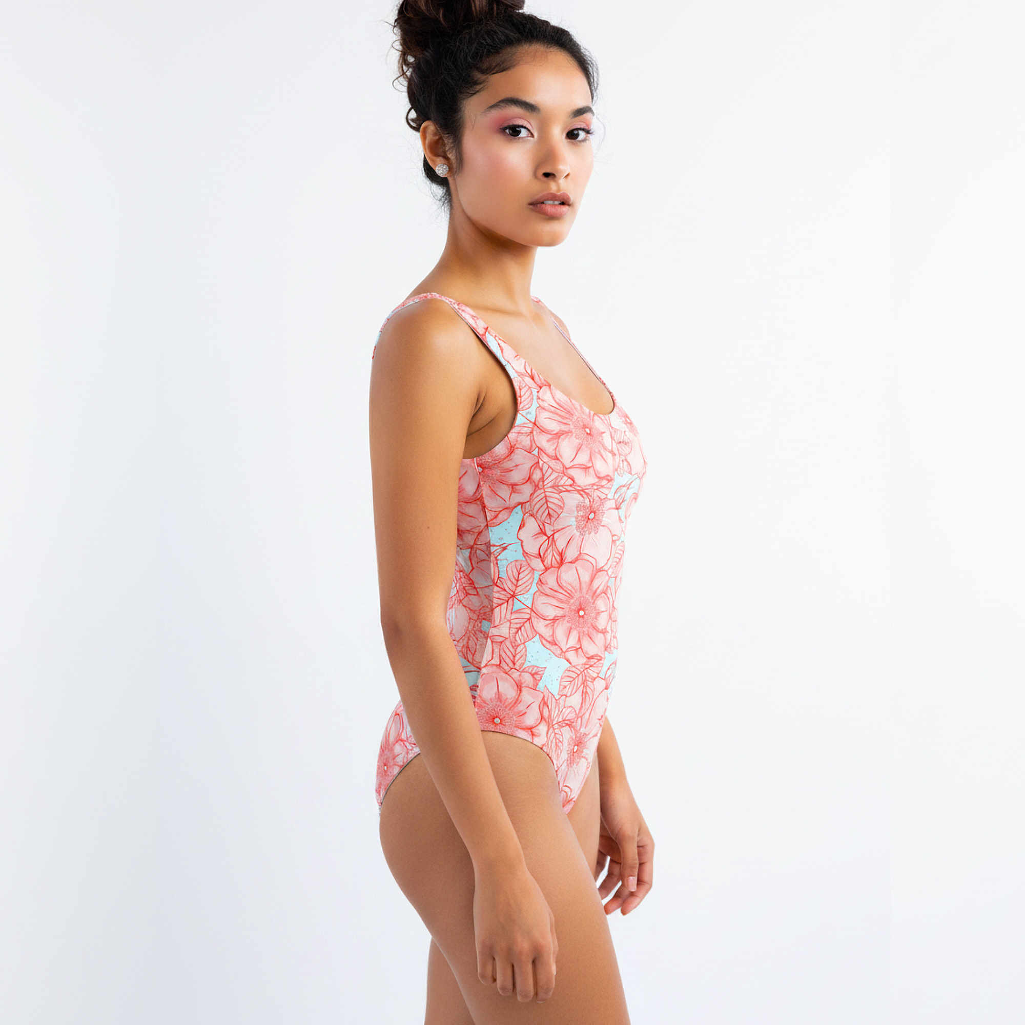 Woman wearing a pink floral swimsuit on a white background