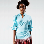 Woman wearing a light blue top with a plain background