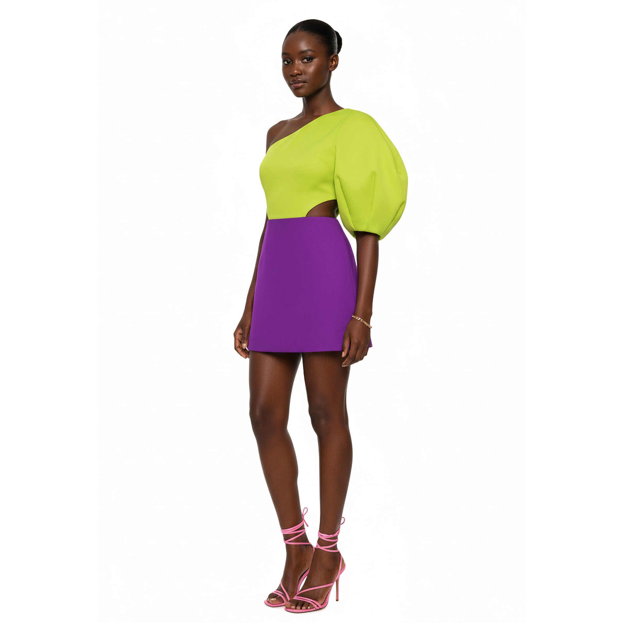Model wearing a bright green top and purple skirt on a white background