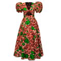 A red and green patterned African wax print maxi dress with puff sleeves, a V-neckline, and a tie detail at the bust, shown against a plain white background.