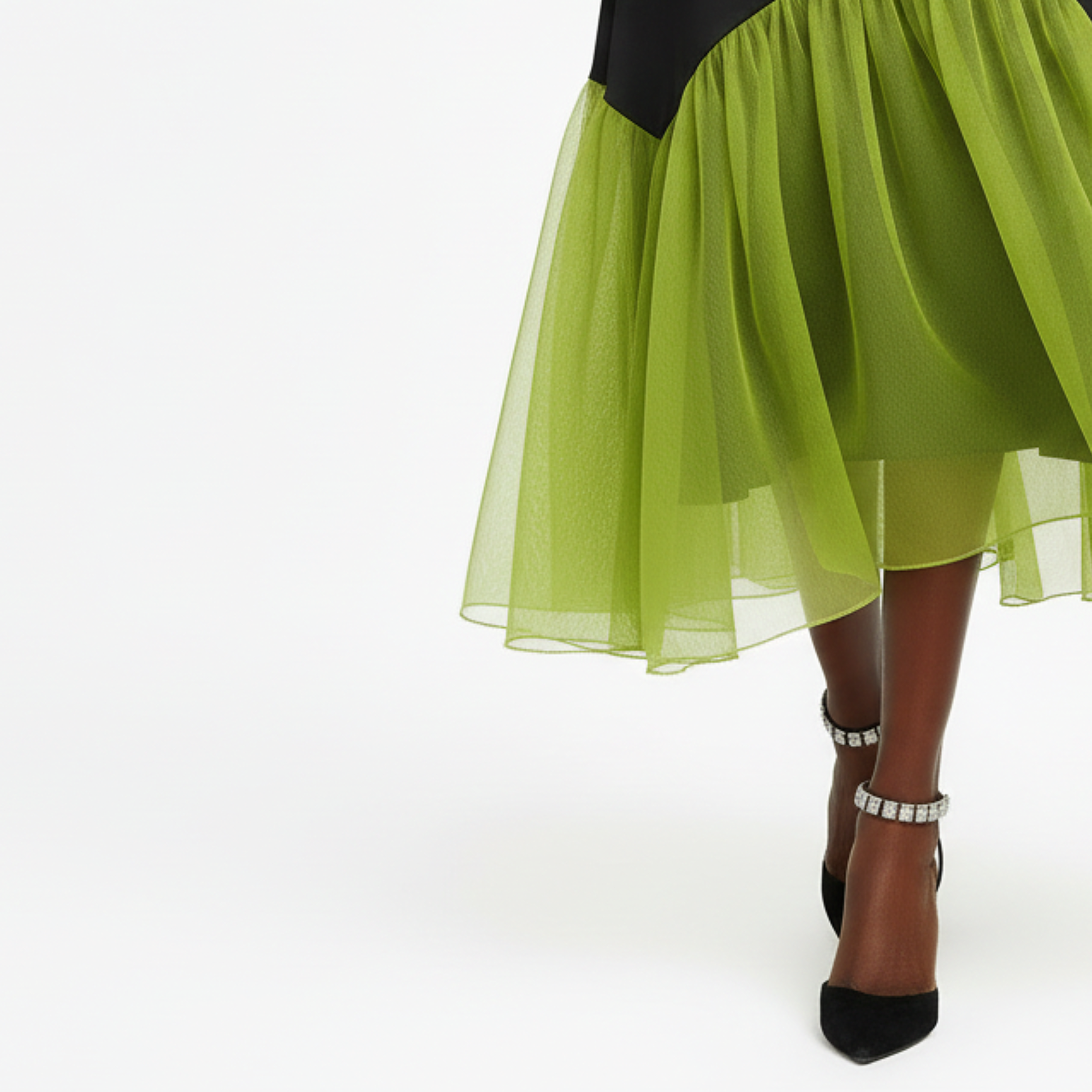 Green sheer skirt with black top and shoes on a white background