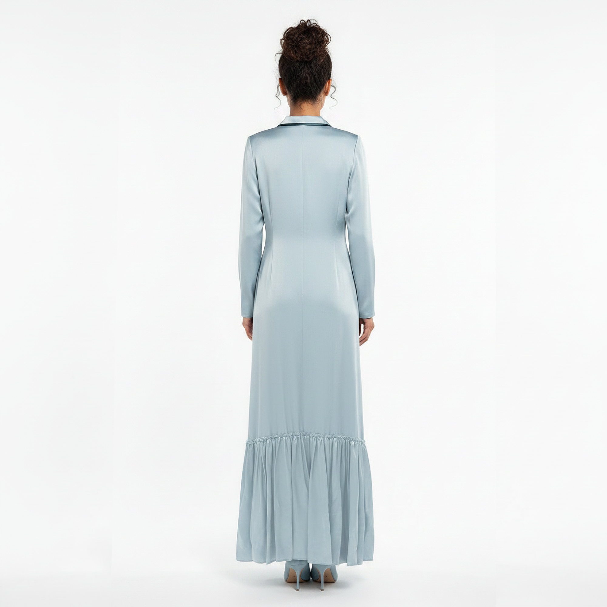 Woman wearing a light blue dress with a ruffled skirt on a white background