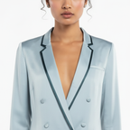 Light blue blazer with black trim worn by a model on a white background
