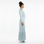 Woman wearing a light blue dress with a white background