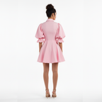 Woman wearing a pink dress on a white background