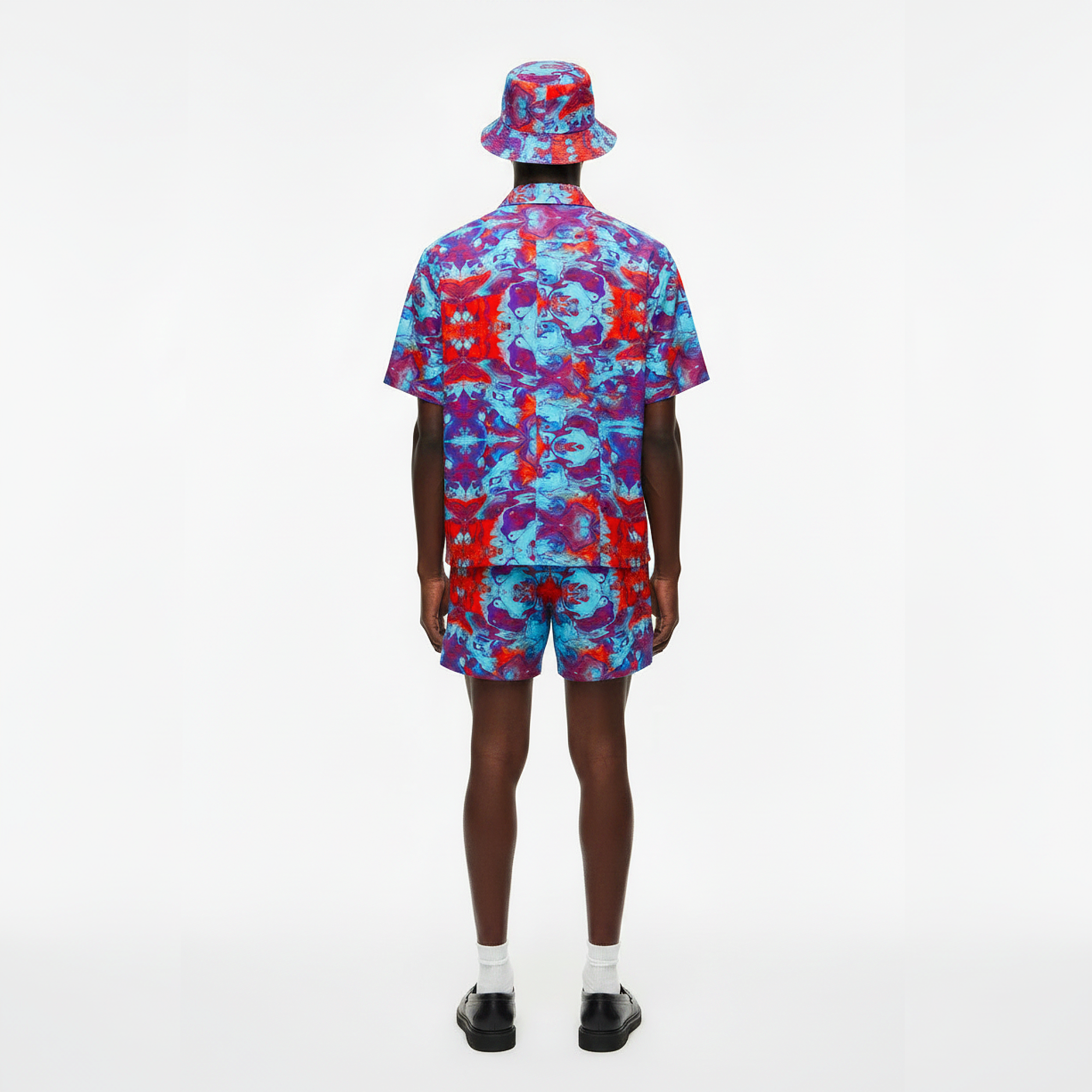 Person wearing a colorful shirt, shorts, and bucket hat on a white background