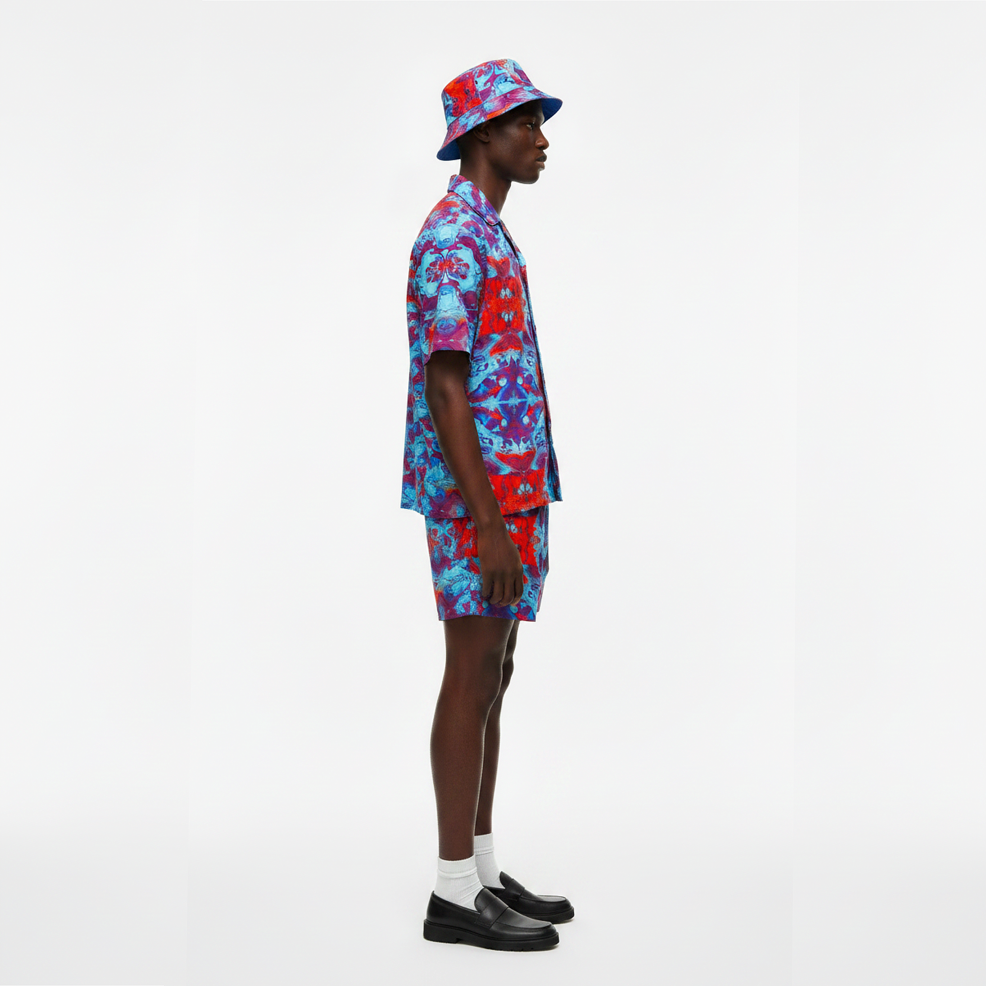 Person wearing a colorful outfit with a matching hat on a white background