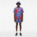 Person wearing a colorful patterned outfit with a hat on a white background