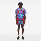 Person wearing a colorful patterned outfit with a hat on a white background
