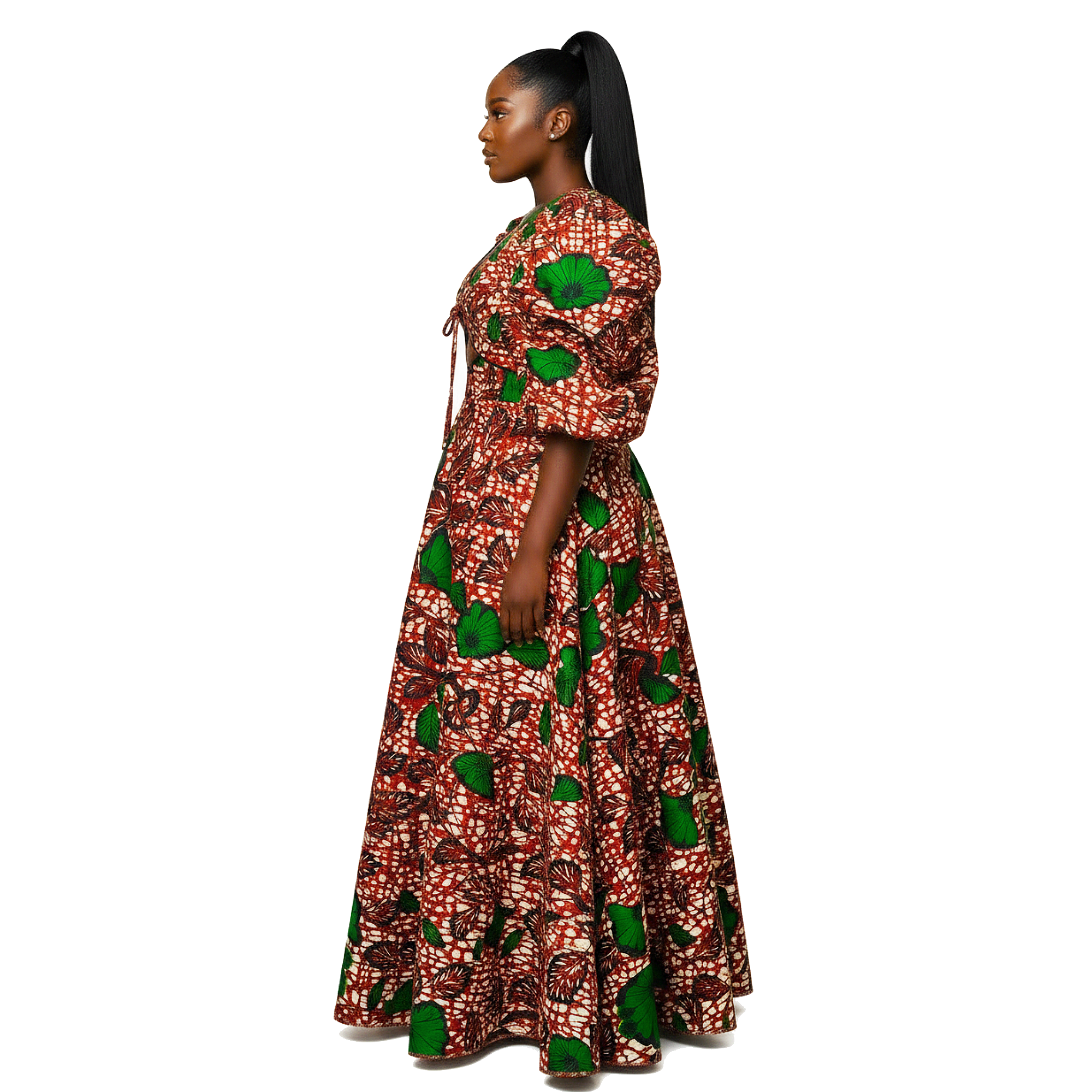 A woman in profile wearing a long, puff-sleeved maxi dress with a vibrant red, green, and white African wax print pattern, set against a plain white background.