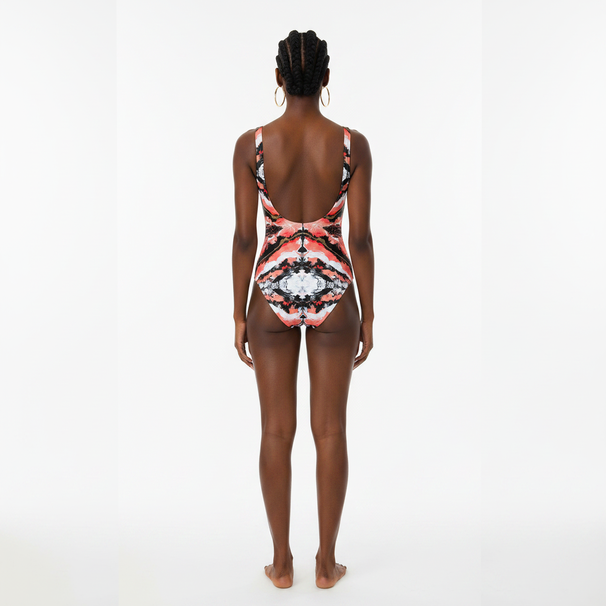Person wearing a colorful one-piece swimsuit on a white background