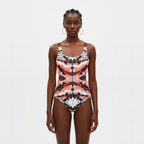 Woman wearing a patterned swimsuit on a light gray background