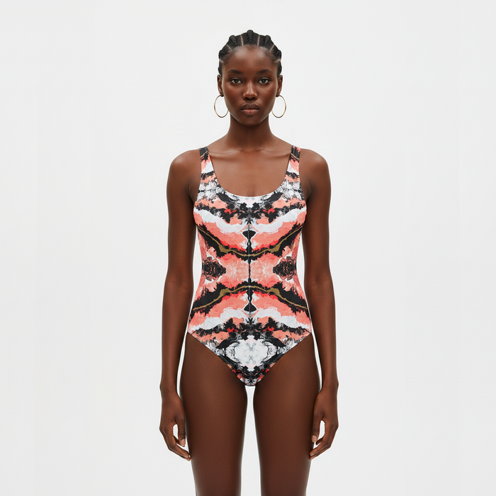 Woman wearing a patterned swimsuit on a light gray background