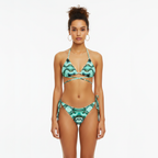Woman wearing a green and black patterned bikini on a white background