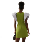Woman wearing a green dress with white puffed sleeves on a white background