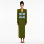 Woman wearing a green dress with blue accents on a white background