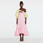 Woman wearing a pink dress with yellow sleeves on a white background
