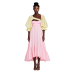 Model wearing a pink dress with a yellow cardigan on a white background
