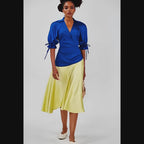 Woman wearing a dress with a  blue top and yellow skirt on a white background