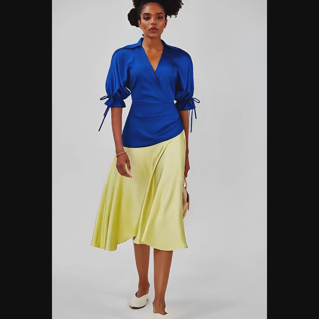 Woman wearing a dress with a  blue top and yellow skirt on a white background
