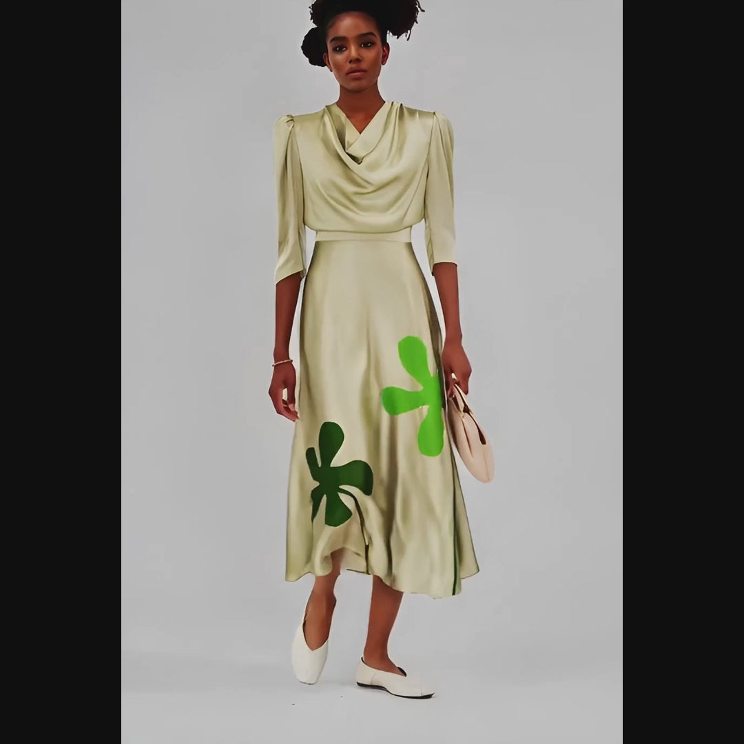 Woman wearing a beige dress with green clover patterns on a white background